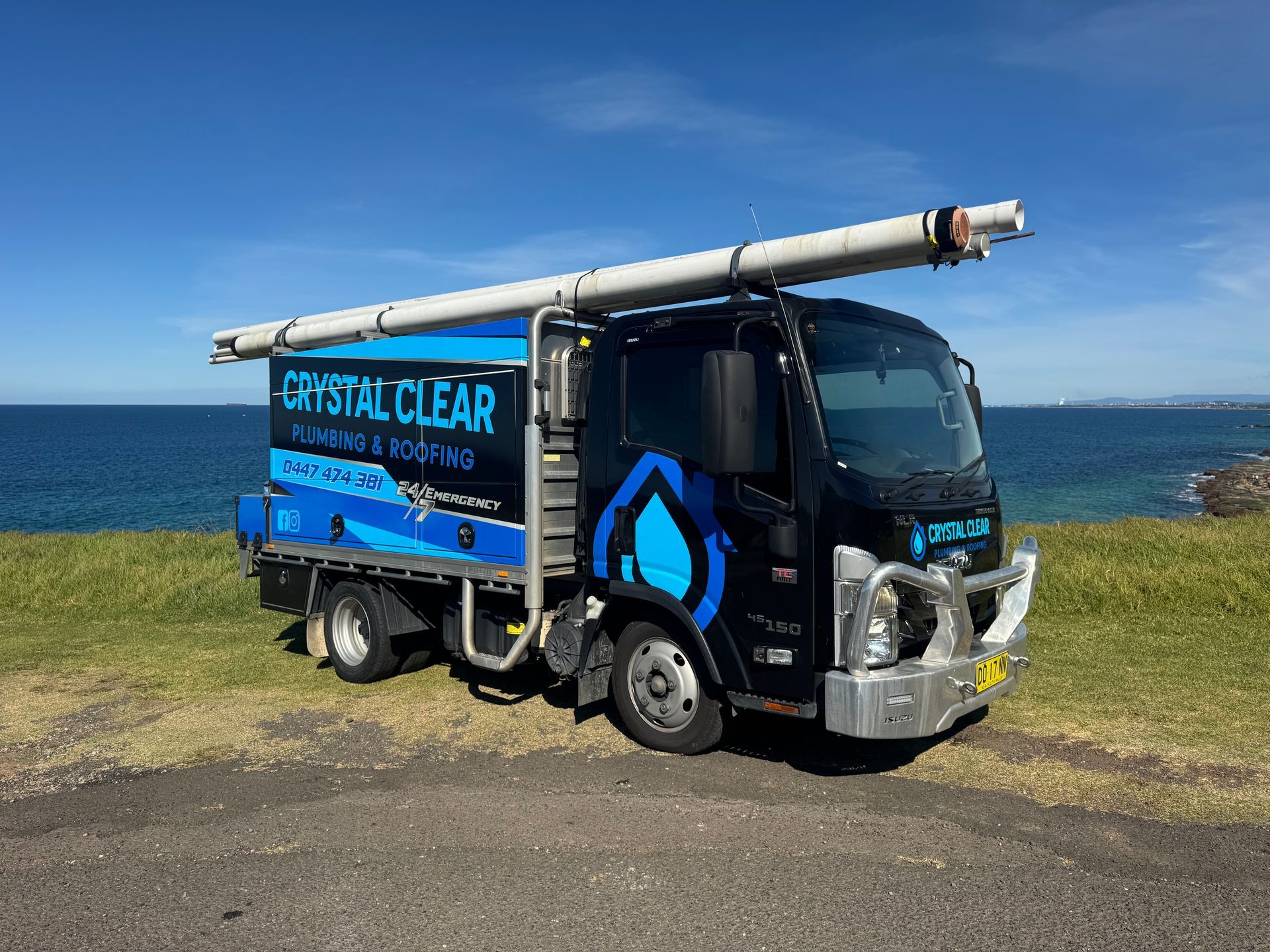 Blue Crystal Clear truck parked on a road, with company logo and phone number on the side — Crystal Clear Plumbing & Roofing in Wollongong, NSW
