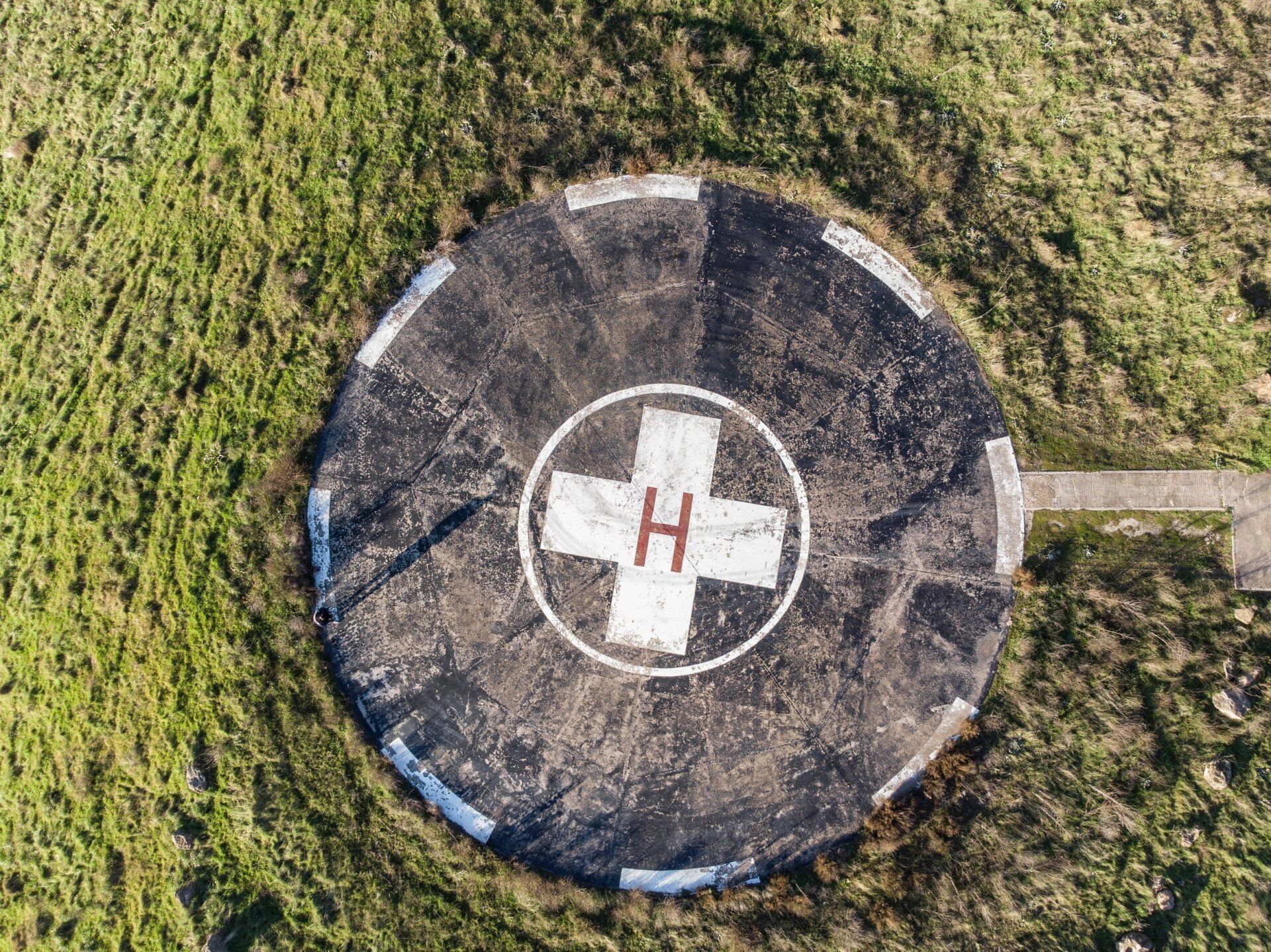an aerial view of a helicopter landing pad in the middle of a field .