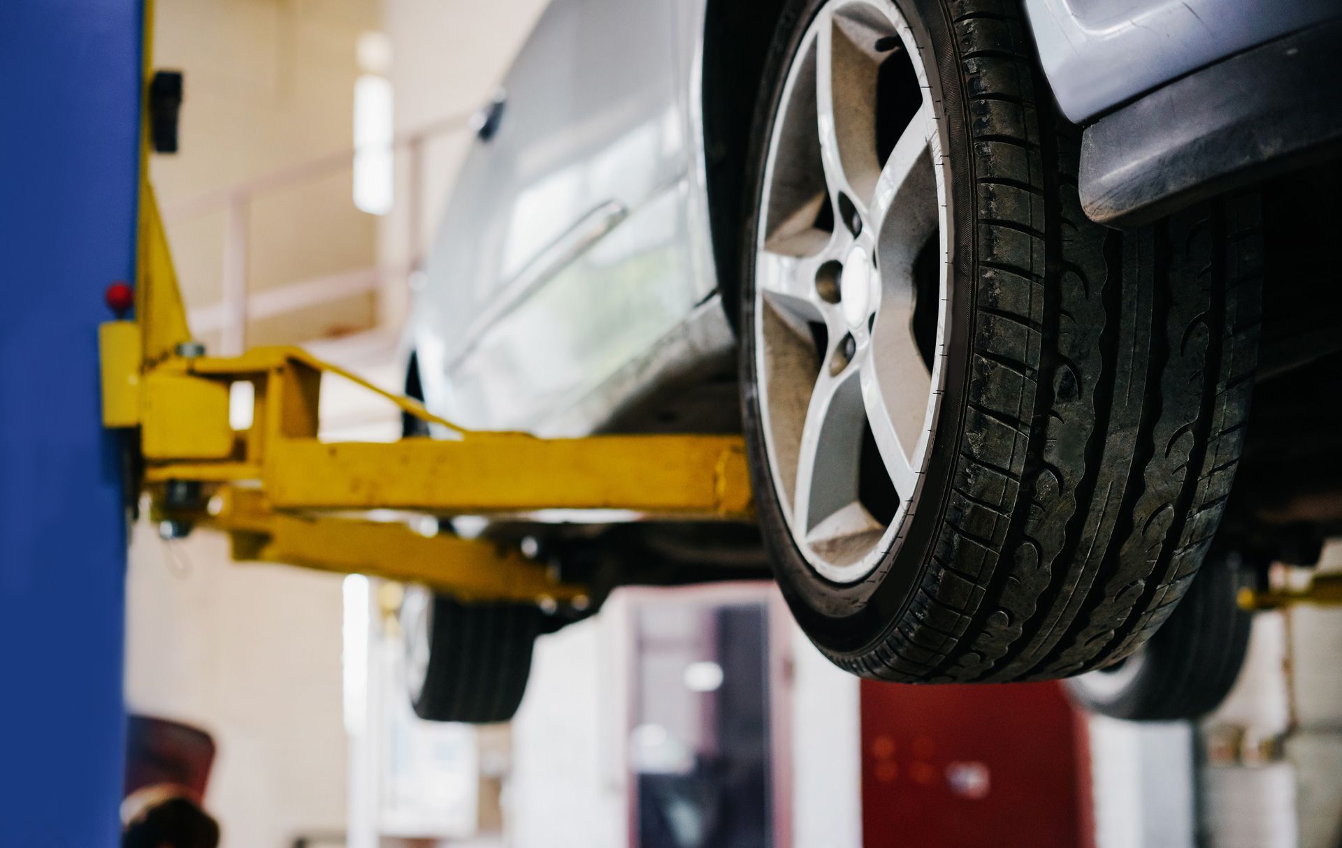 A car is sitting on a lift in a garage.