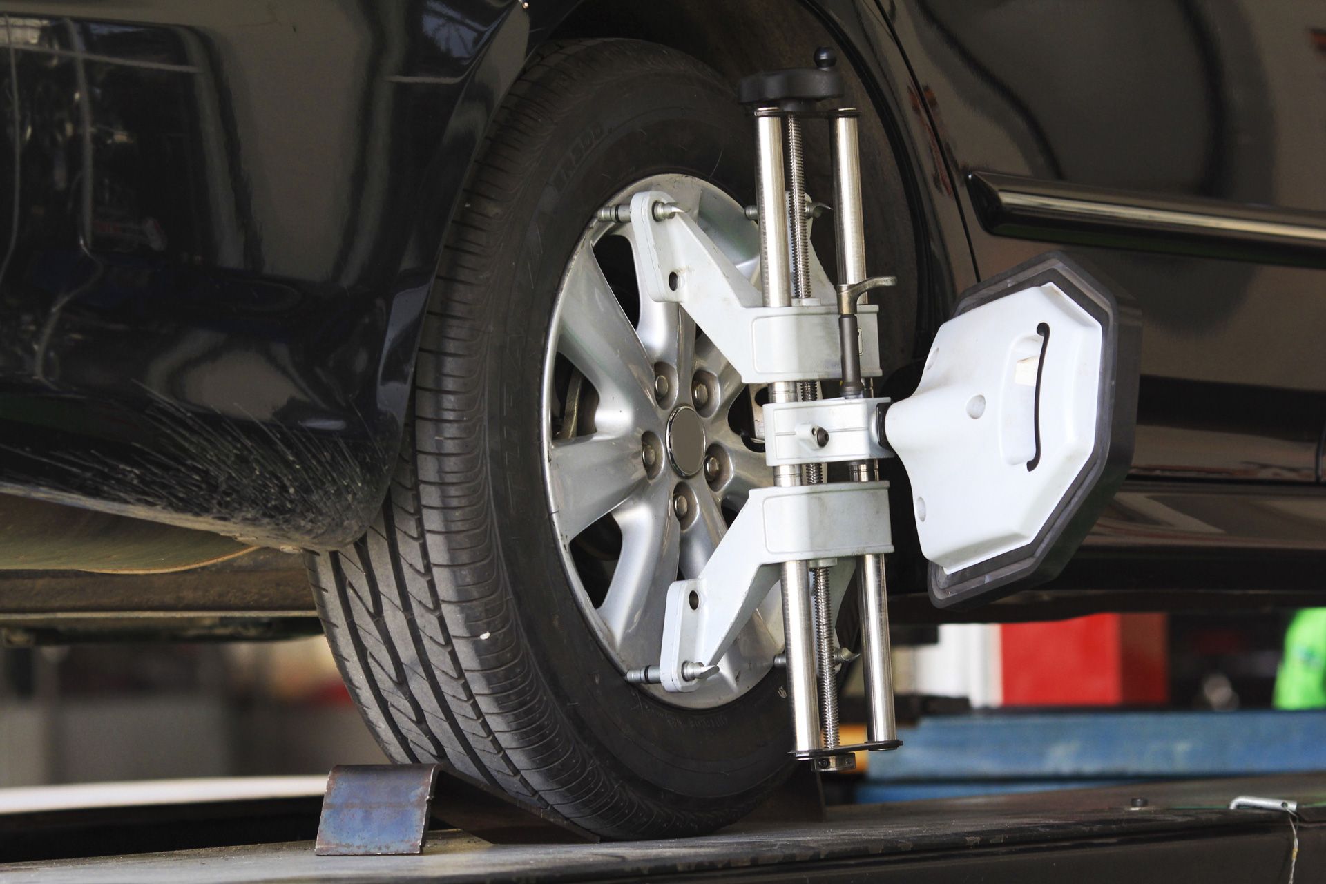 A car is being aligned with a machine in a garage.