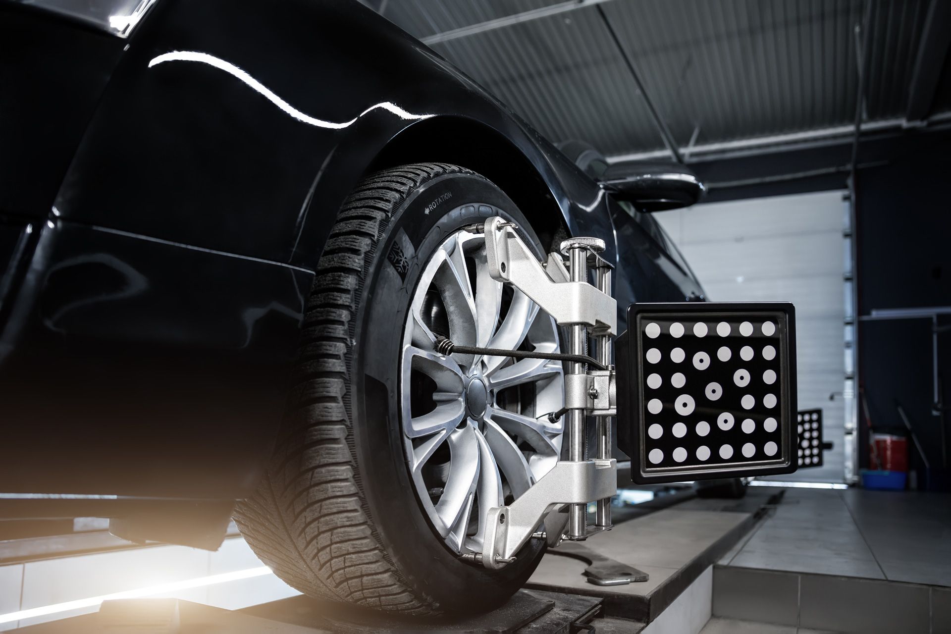A car is being adjusted by a machine in a garage.