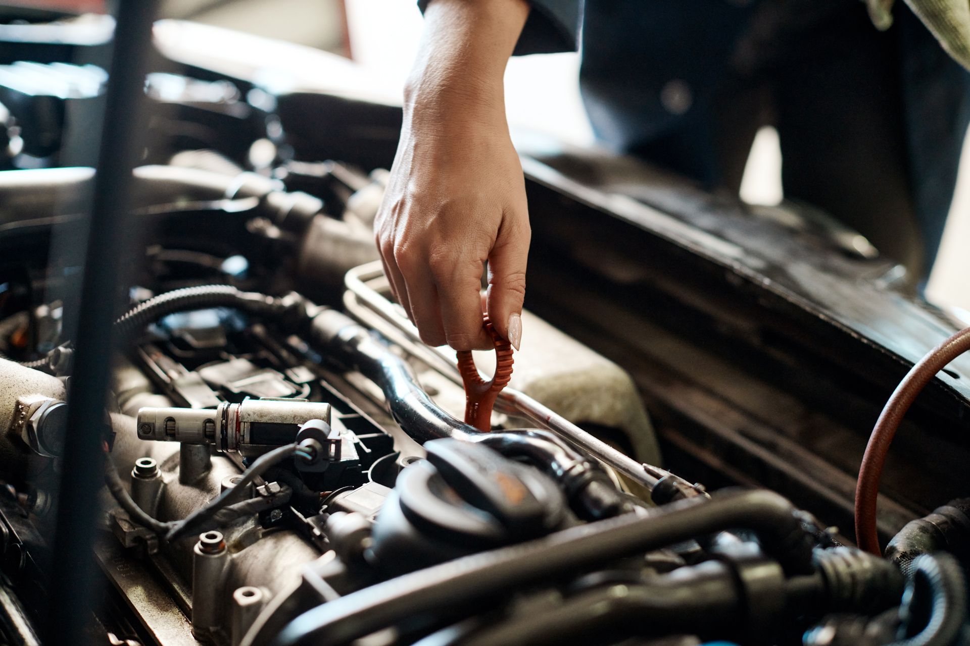 A person is checking the oil level of a car engine.