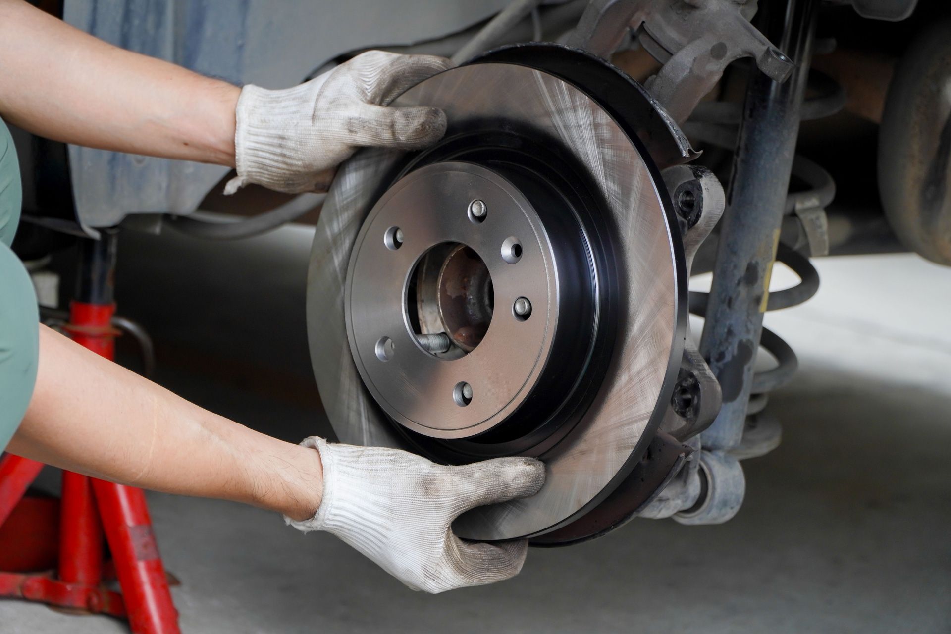 A person is fixing a brake disc on a car.