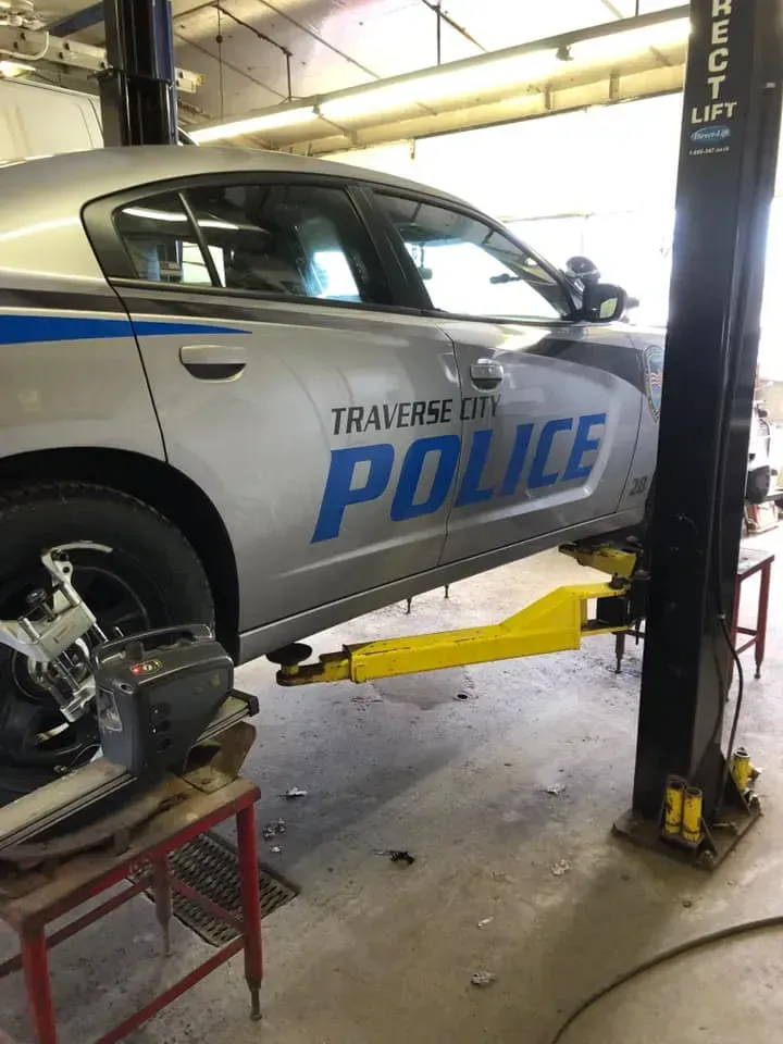 A police car is on a lift in a garage.
