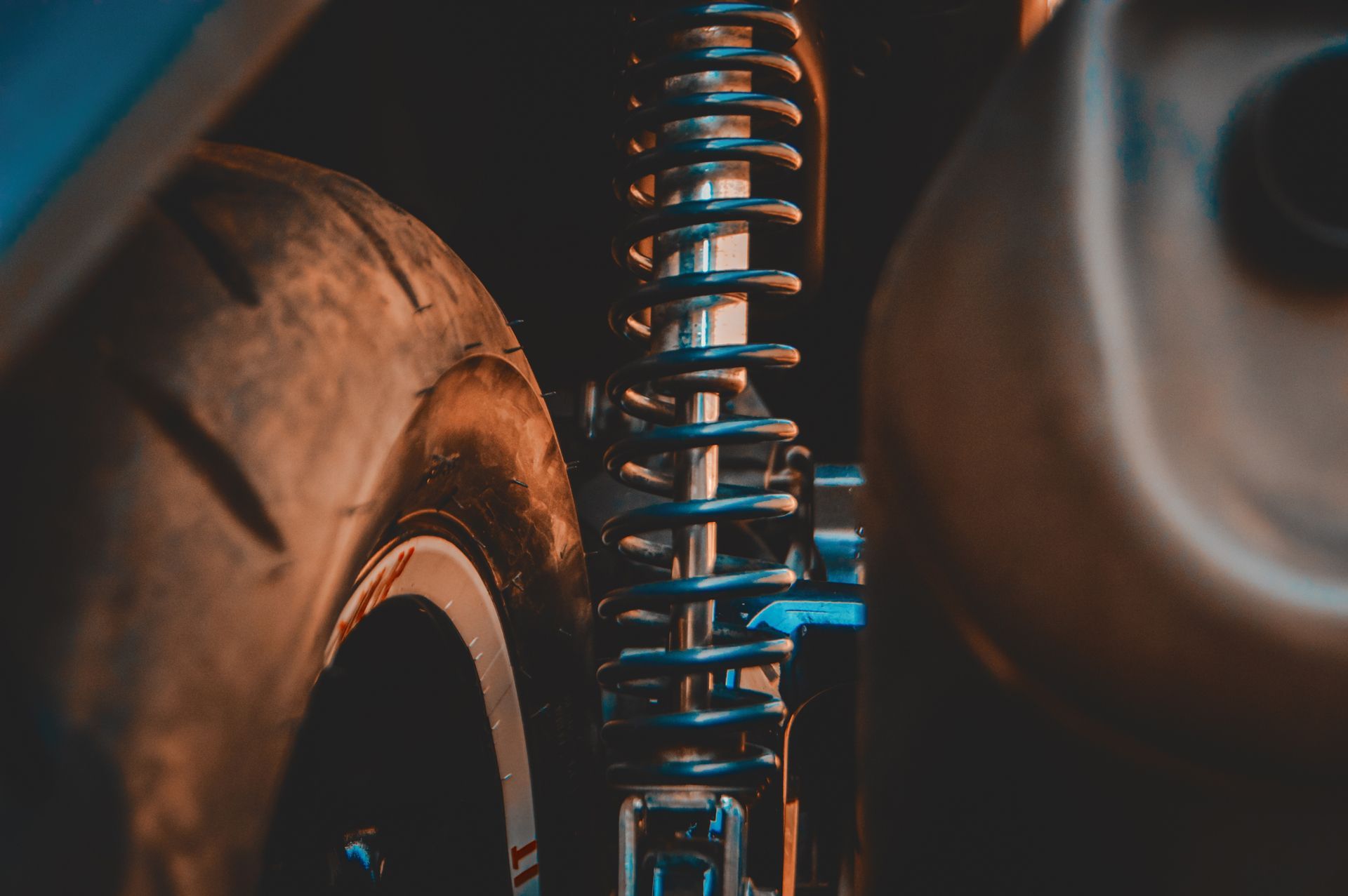 A close up of a motorcycle shock absorber and tire.