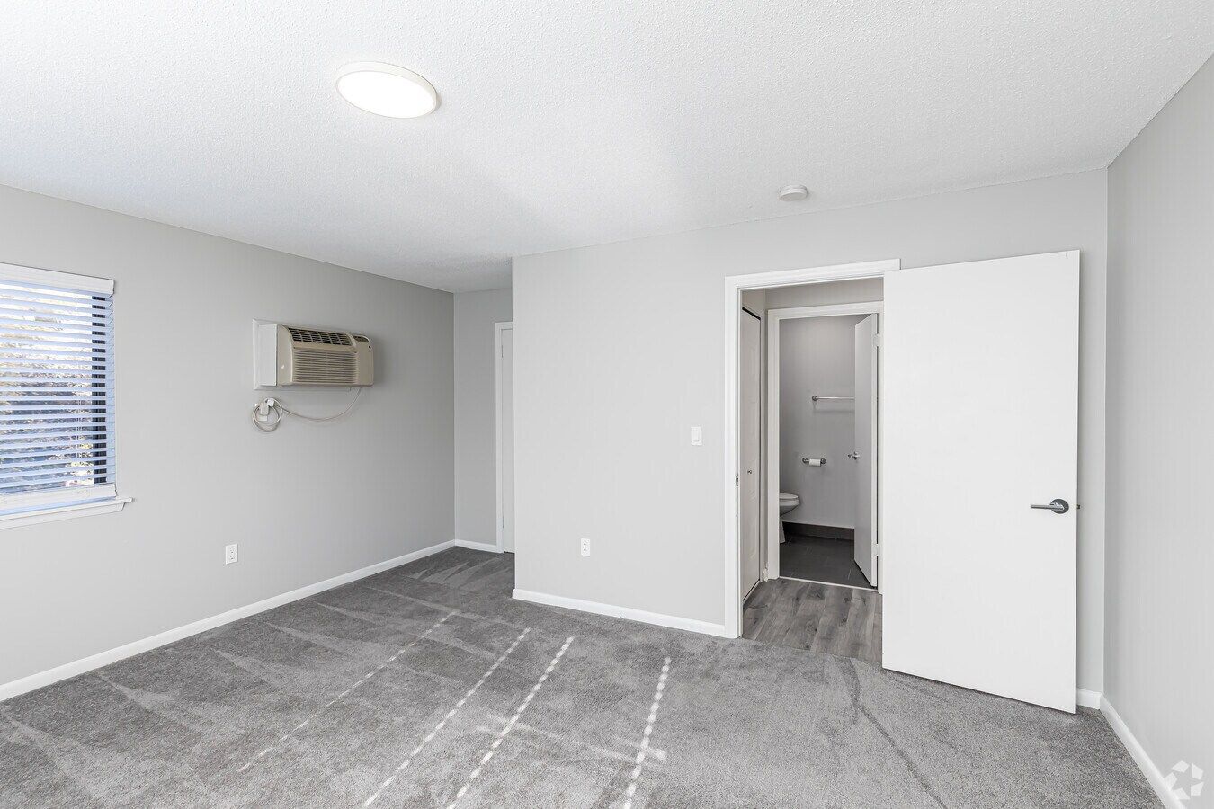 Living area with sliding door in a one-bedroom Avon Woods apartment