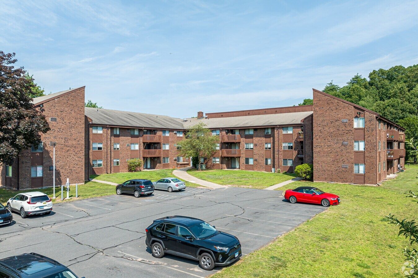 Exterior view of Avon Woods Apartments parking area and buildings