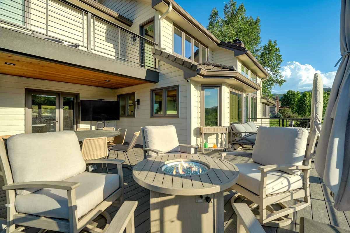 Patio with wicker seating and table outside a modern house on a sunny day