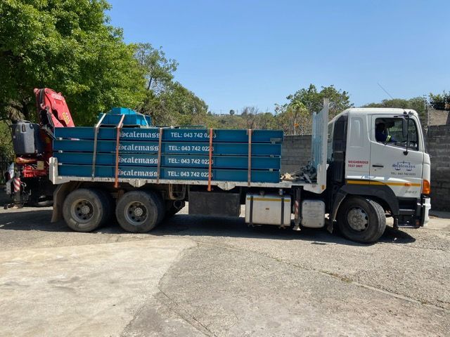 A truck with a crane attached to it is parked in a parking lot.