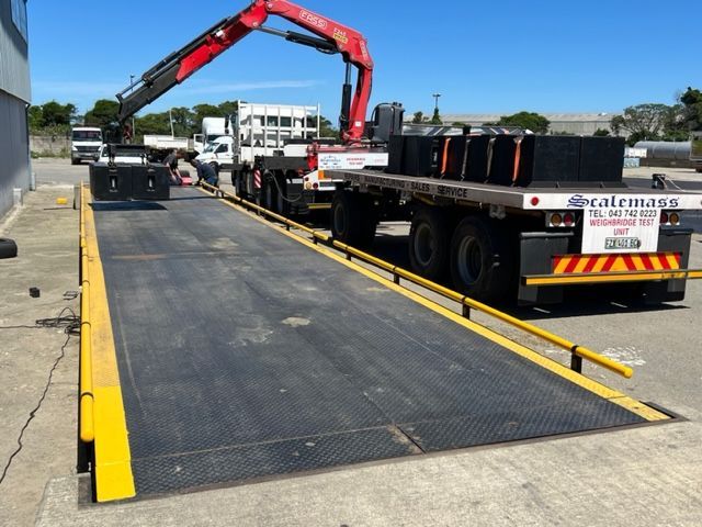 A scalemass truck is being weighed by a crane