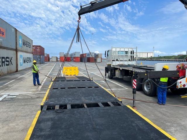 A truck is being lifted by a crane in a parking lot.