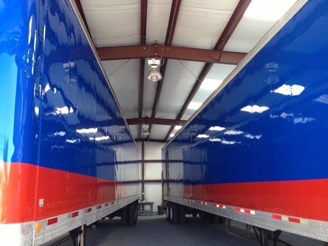 a red white and blue trailer is parked in a warehouse