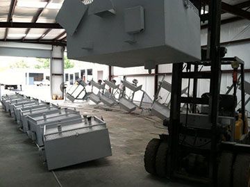 a forklift is lifting a large piece of metal in a warehouse .