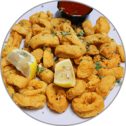 A plate of fried shrimp with a slice of lemon and dipping sauce.
