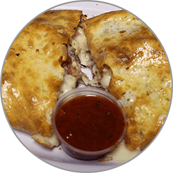 A close up of a pizza with a dipping sauce on a plate.