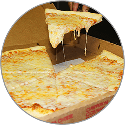 A person is taking a slice of cheese pizza out of a box.