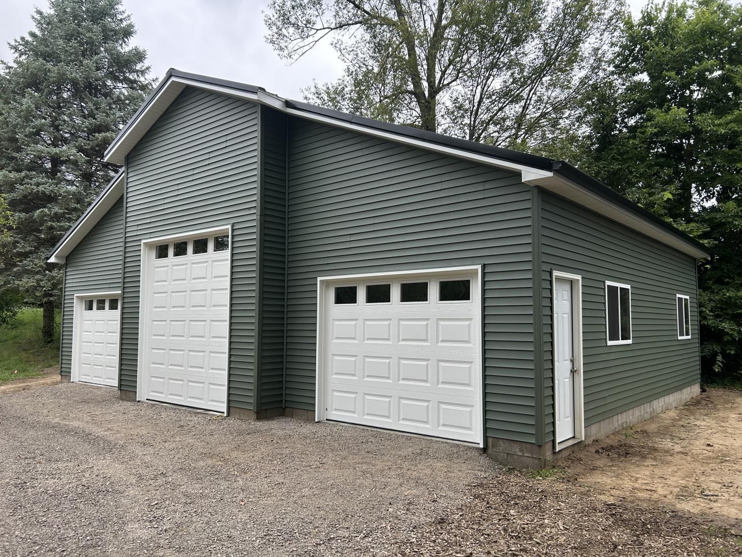 An empty barn with a concrete floor and a wooden roof.