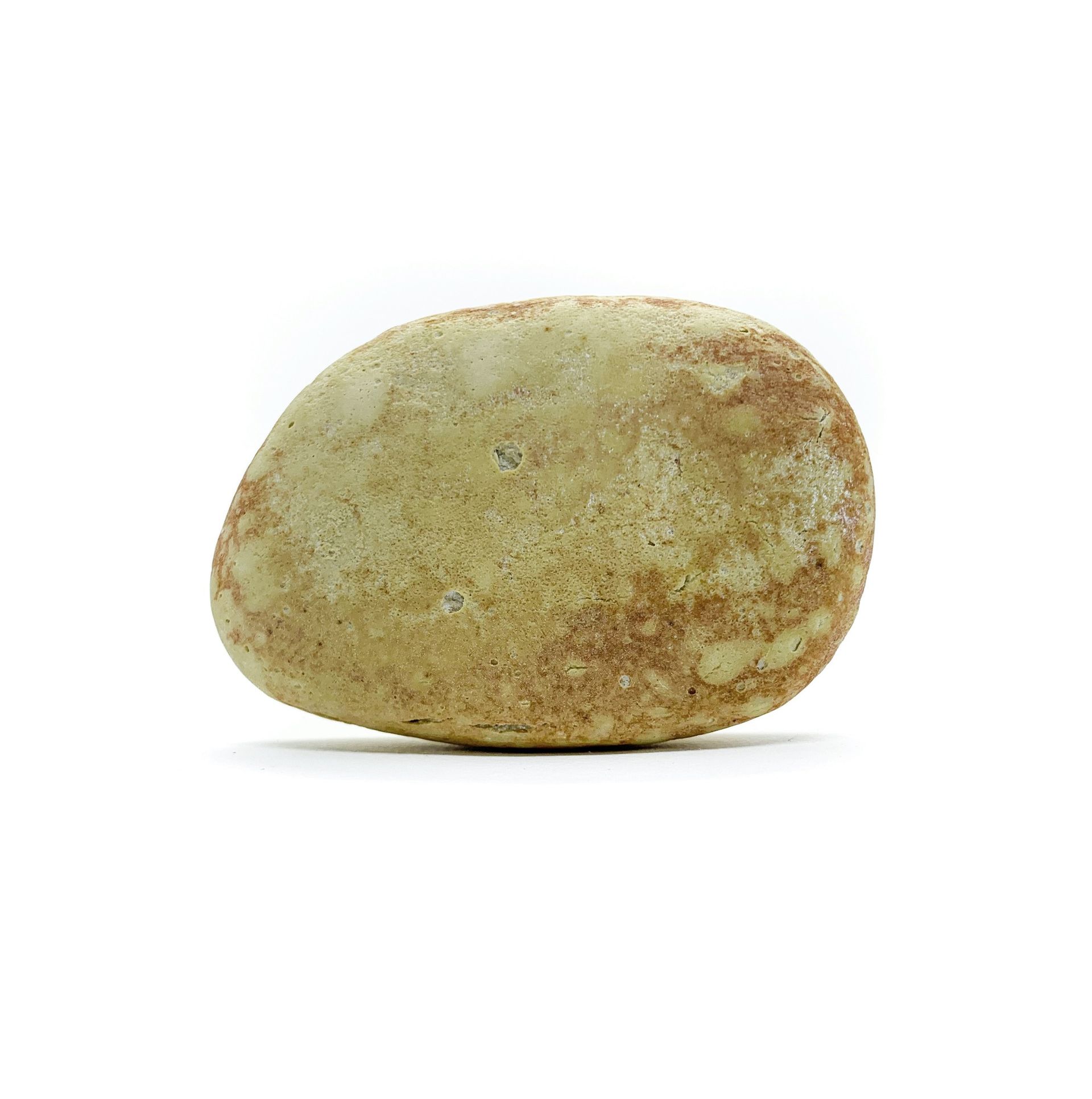 Tan, oval-shaped rock with reddish-brown speckles on a white background.