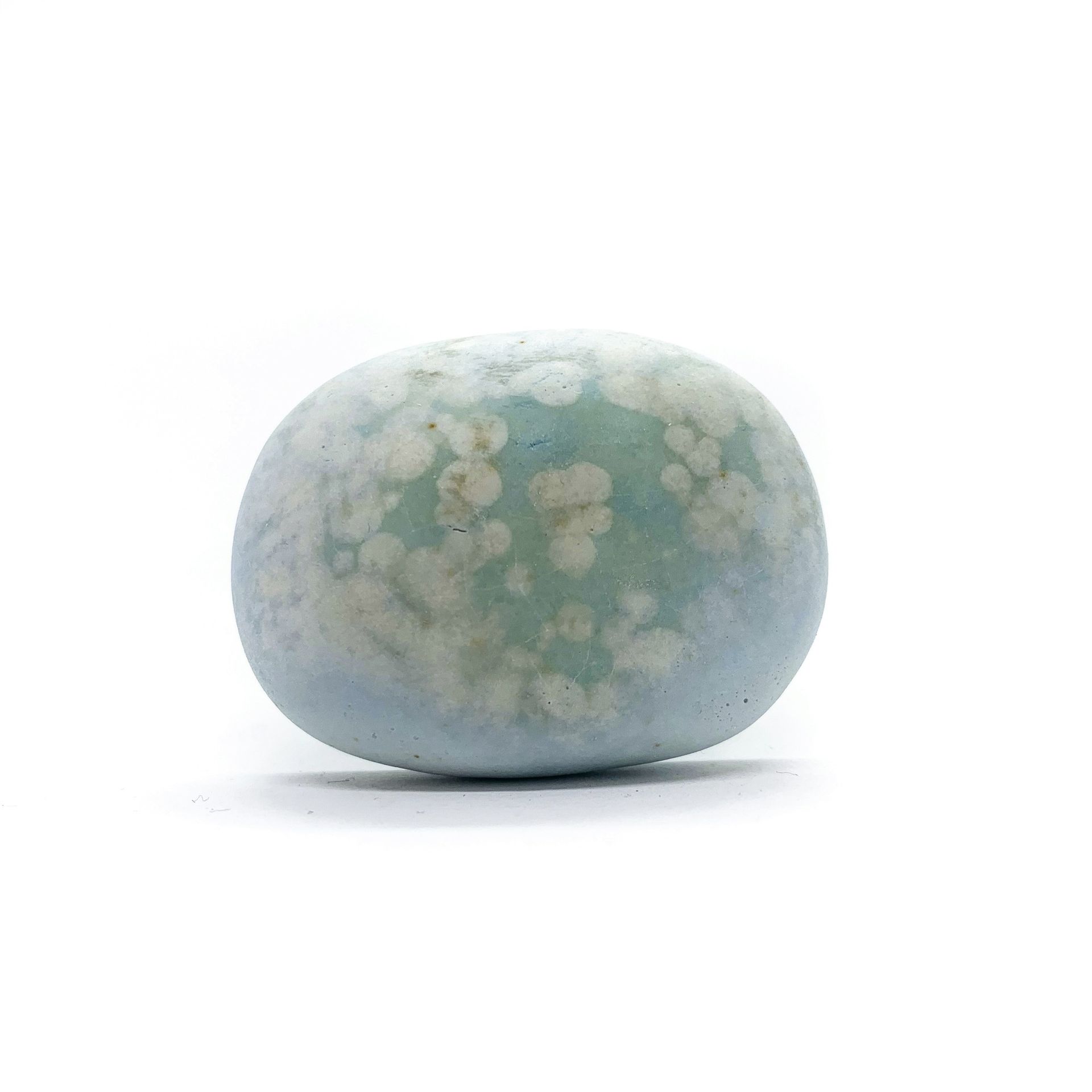 Blue-green rock with white mottled pattern, on a white background.