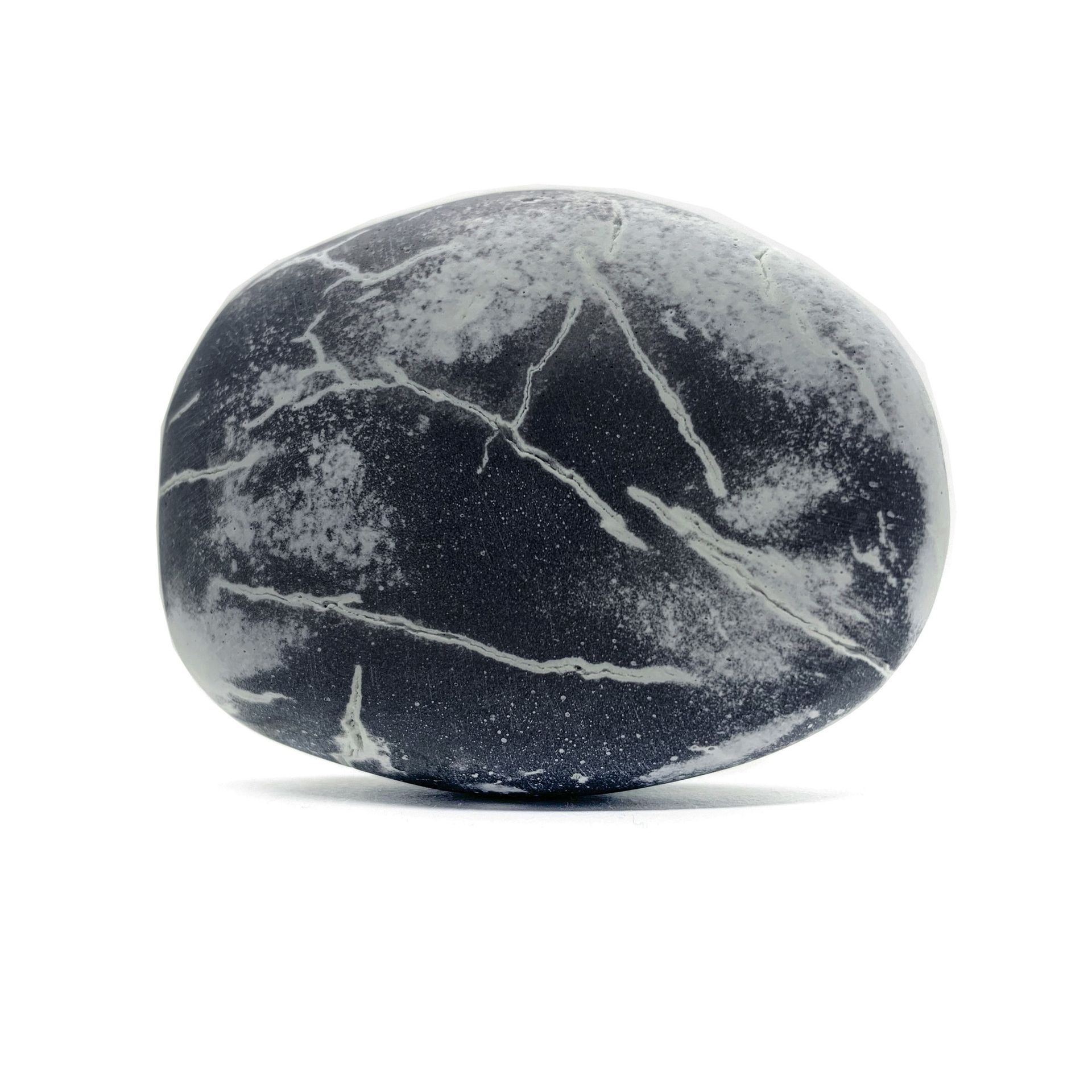 Smooth, dark gray stone with white cracks, isolated on white background.