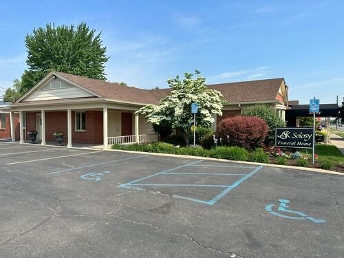 Exterior view of a Sawyer Funeral Home, a single-story brick building, with accessible parking.