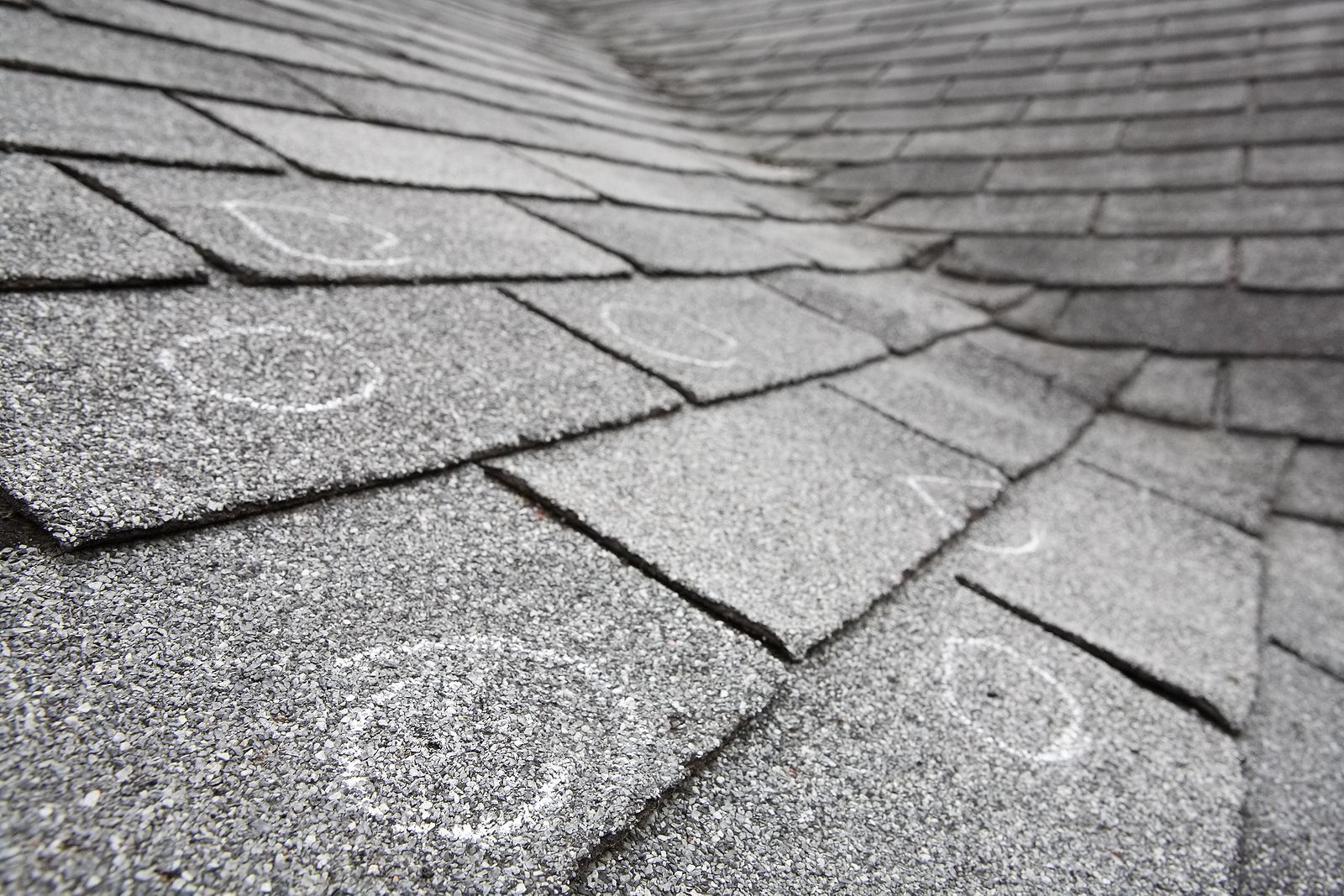 Asphalt shingle roof with visible hail damage; circular markings and divots.