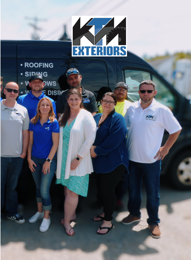 Group of people in front of a wall of ladders. Some wear company shirts. Daylight setting.