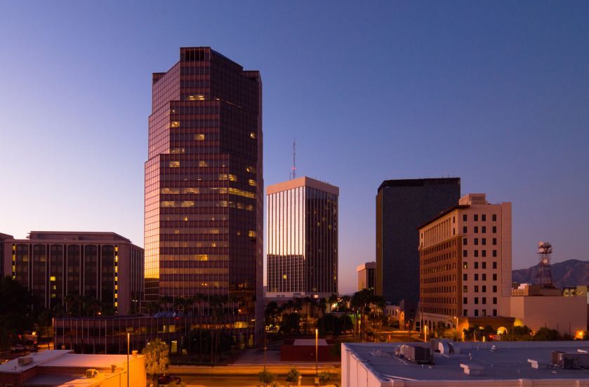 Silhouette of saguaro cacti and mountains against a colorful sunset sky.