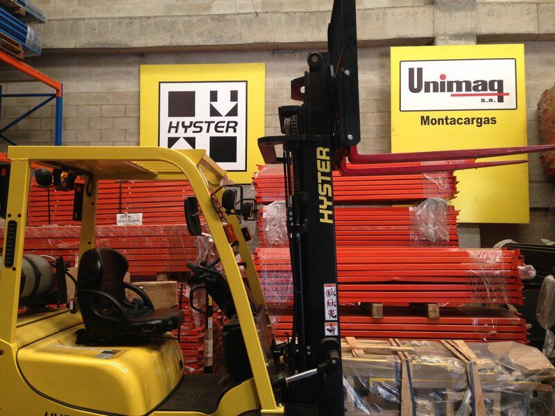 Una carretilla elevadora Hyster amarilla está estacionada en un almacén