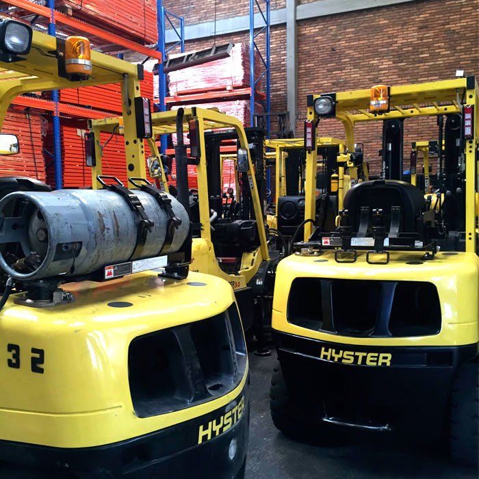 Una fila de carretillas elevadoras Hyster amarillas en un almacén