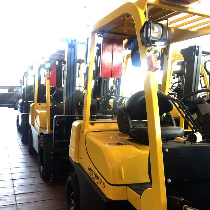 Una fila de carretillas elevadoras amarillas están estacionadas una al lado de la otra.
