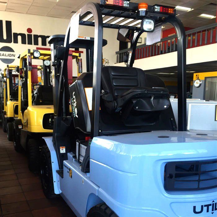 Una fila de carretillas elevadoras estacionadas frente a un cartel que dice unimog