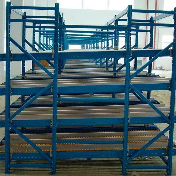 Una fila de estantes azules están alineados en un almacén.