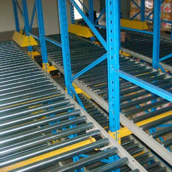 Una fila de cintas transportadoras azules y amarillas en un almacén.