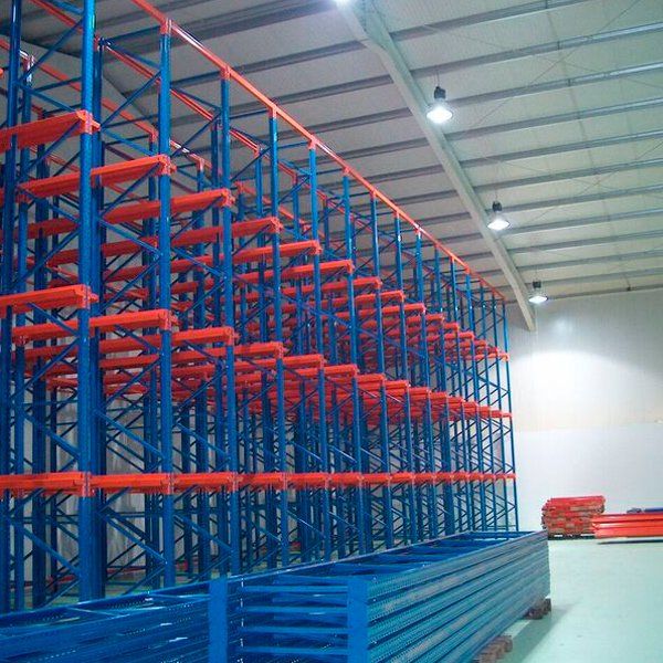 Un almacén lleno de estanterías azules y rojas.