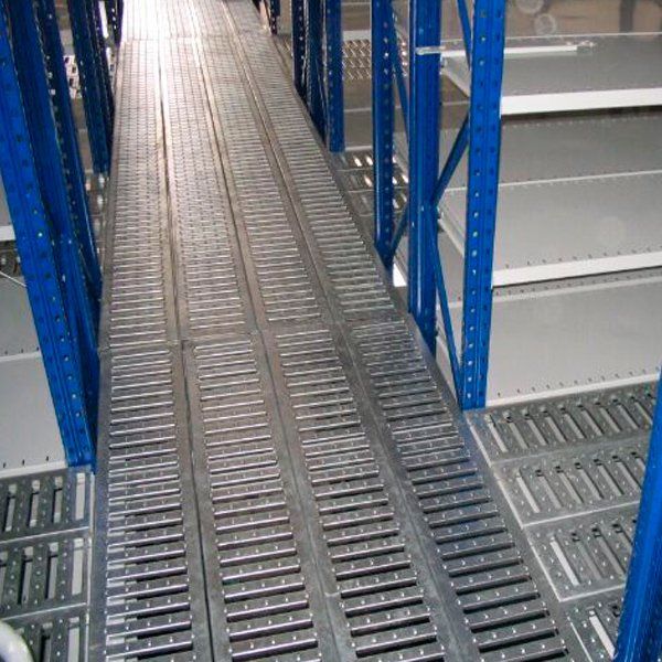 Una pasarela metálica entre dos estanterías de un almacén.