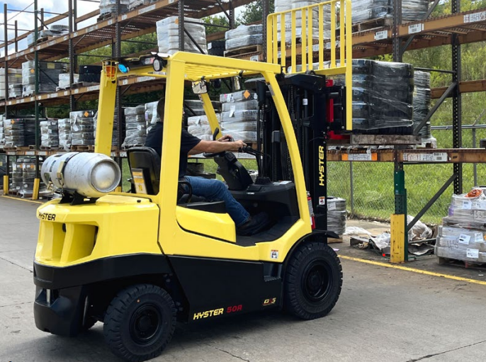 Una carretilla elevadora amarilla está estacionada en un almacén.