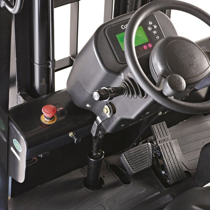 El interior de una carretilla elevadora con un botón rojo de parada de emergencia