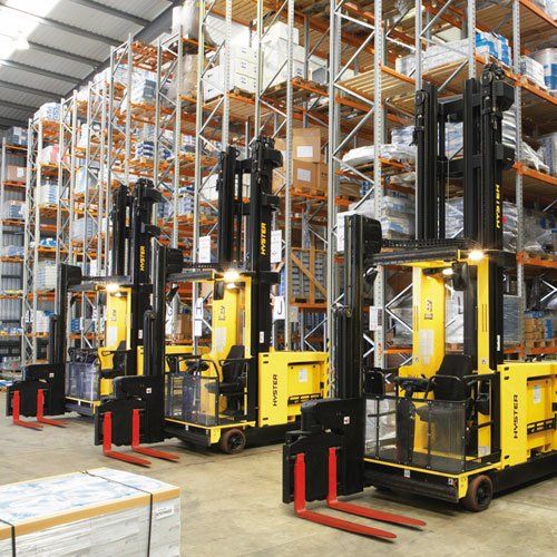 Una fila de carretillas elevadoras está estacionada en un almacén.