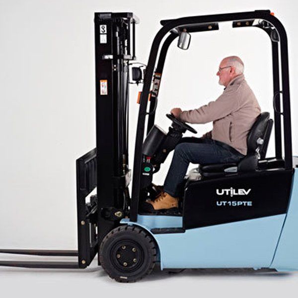 Un hombre conduce una carretilla elevadora azul y negra que dice utilev