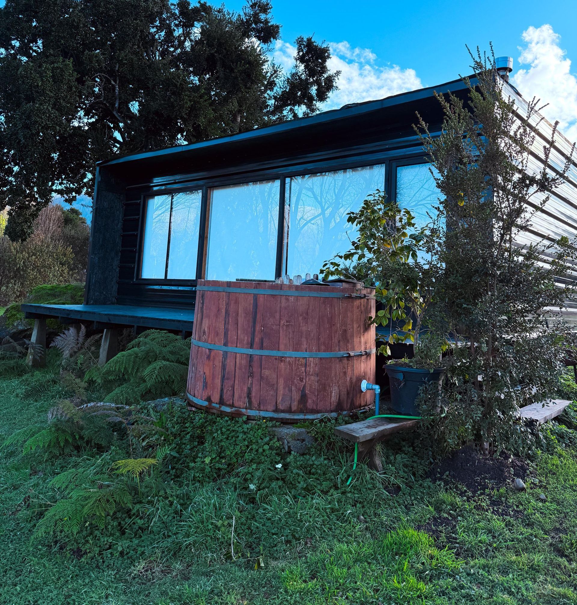 Una tina de madera se encuentra frente a una pequeña casa.
