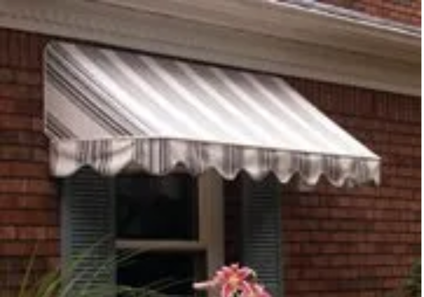 A striped awning is hanging over a window on a brick building.
