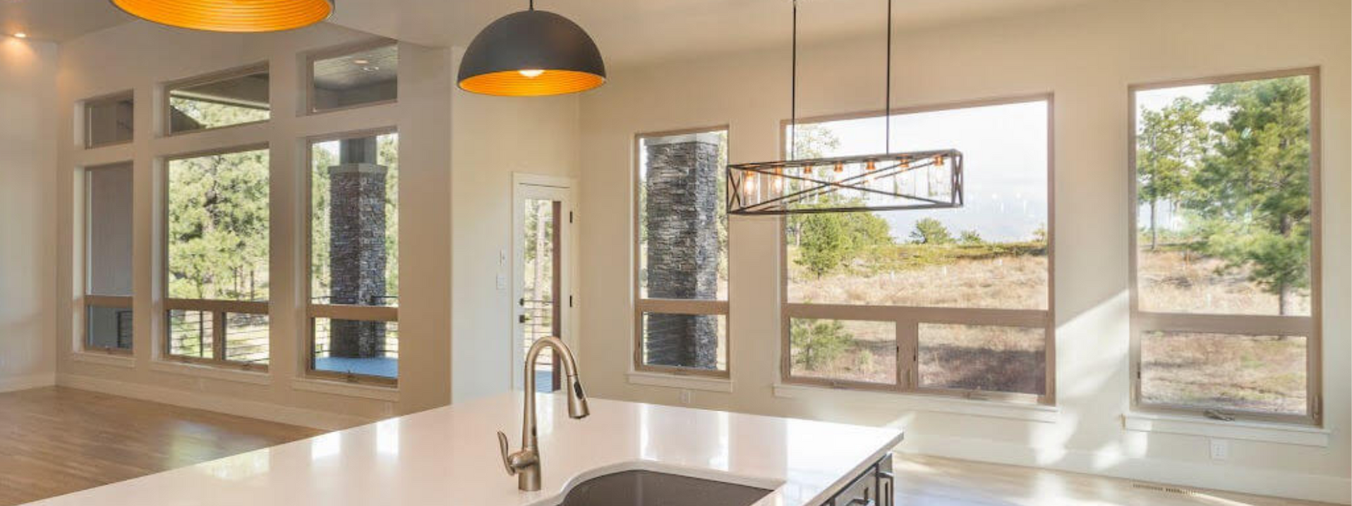 A kitchen with a sink and a lot of windows.