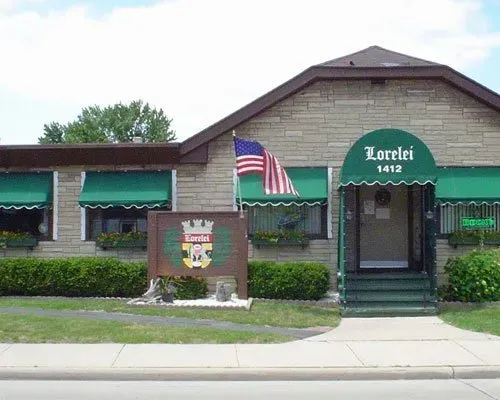 A brick building with a green awning that says lorelei 1412
