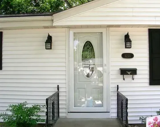 A white house with a white door and black shutters
