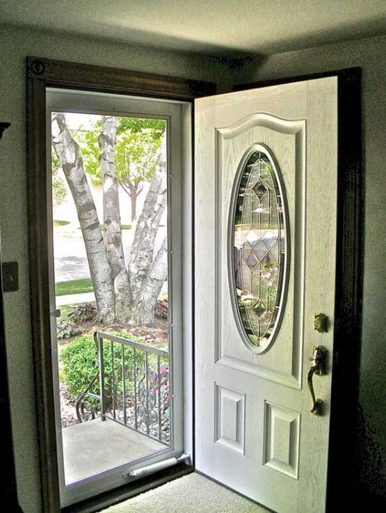 A white door with an oval window is open to a balcony.