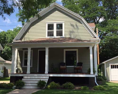 A house with a porch and chairs on it