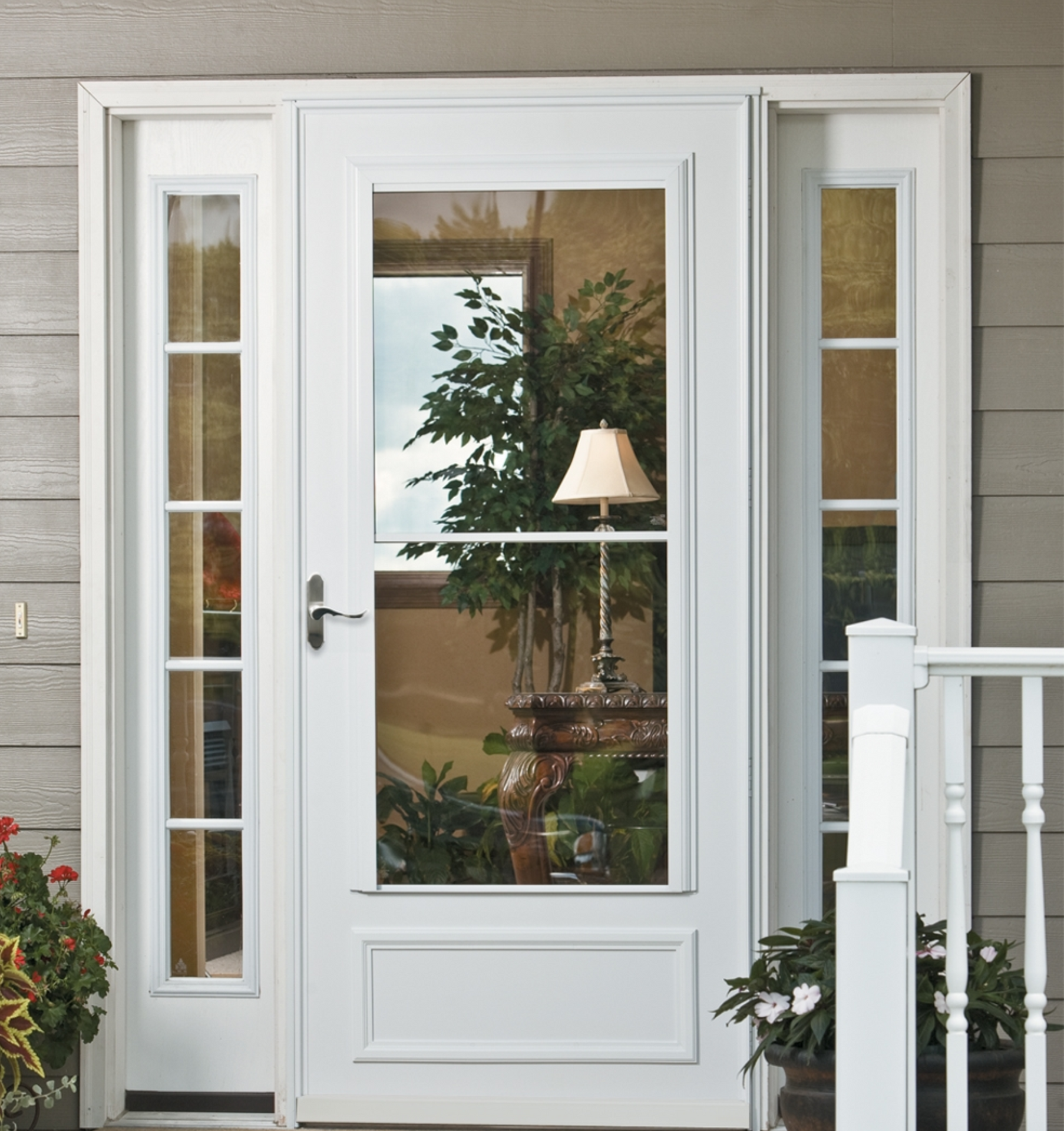 A white door is open to a living room with a lamp