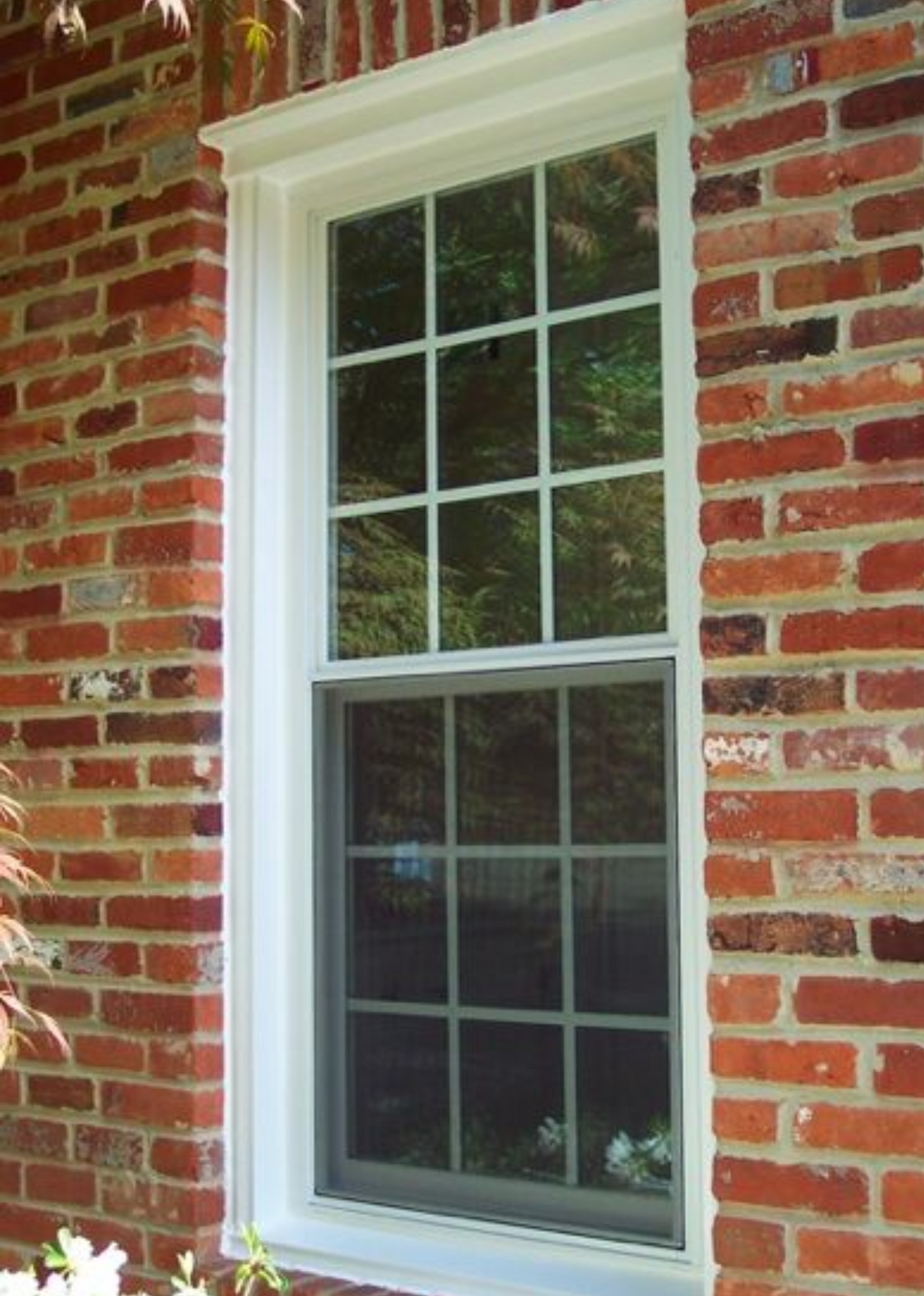 A brick wall with a white window on it