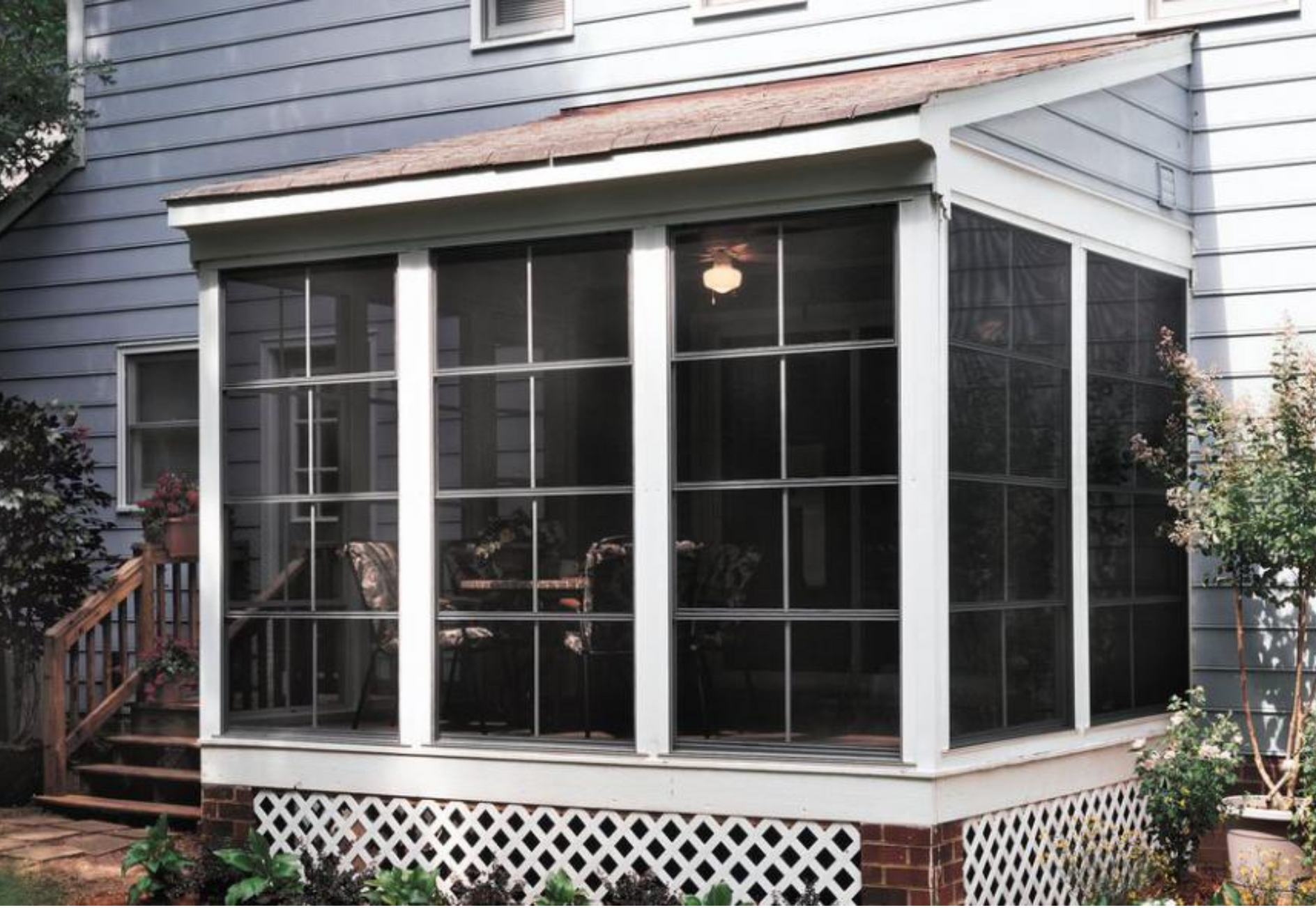 A screened in porch on the side of a house